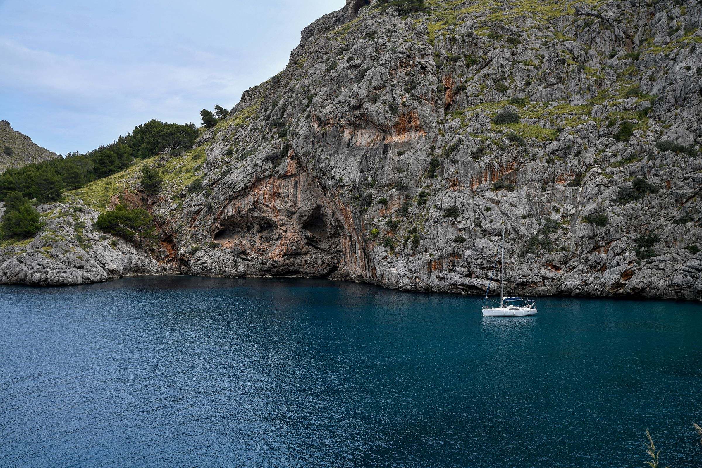 A sailing boat anchored in a turquoise cove in Mallorca